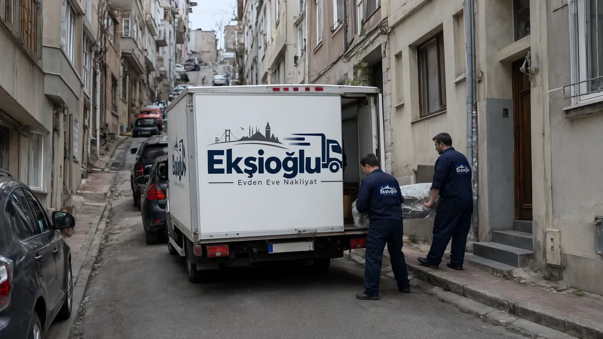Yokuşlu dar sokakta duran küçük kamyondan iki taşıyıcı sarılı koltuğu indirip binaya taşıyor